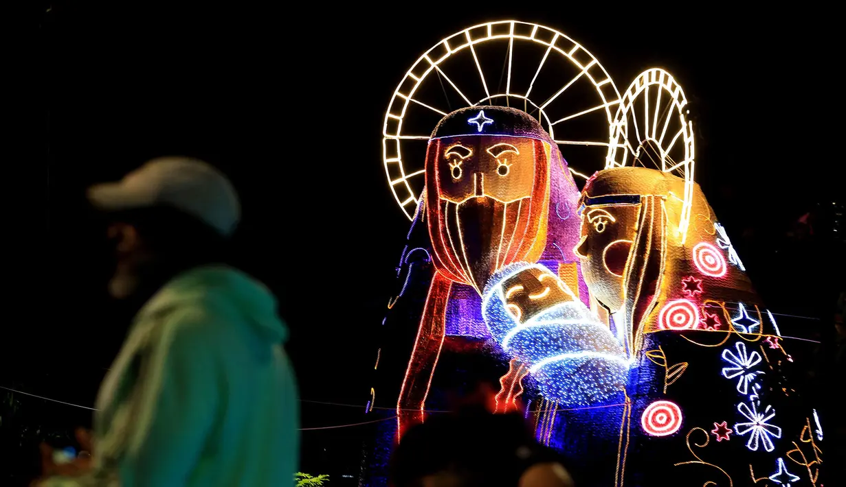 Orang-orang berjalan melewati lampu-lampu Natal tradisional di Medellin, Kolombia, pada tanggal 28 November 2024. (JAIME SALDARRIAGA/AFP)