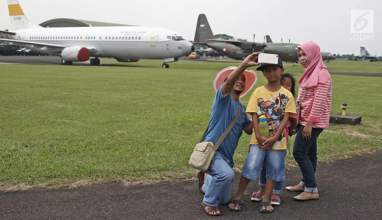 Warga foto di dekat pesawat TNI AU saat pesta rakyat peringatan HUT TNI AU ke-72 di Lanud Halim Perdanakusumah, Jakarta, Sabtu (7/4). Pesta rakyat tersebut sudah dimulai pada Sabtu, 7 April 2018, hingga Senin, 9 April 2018. (Liputan6.com/Herman Zakharia)