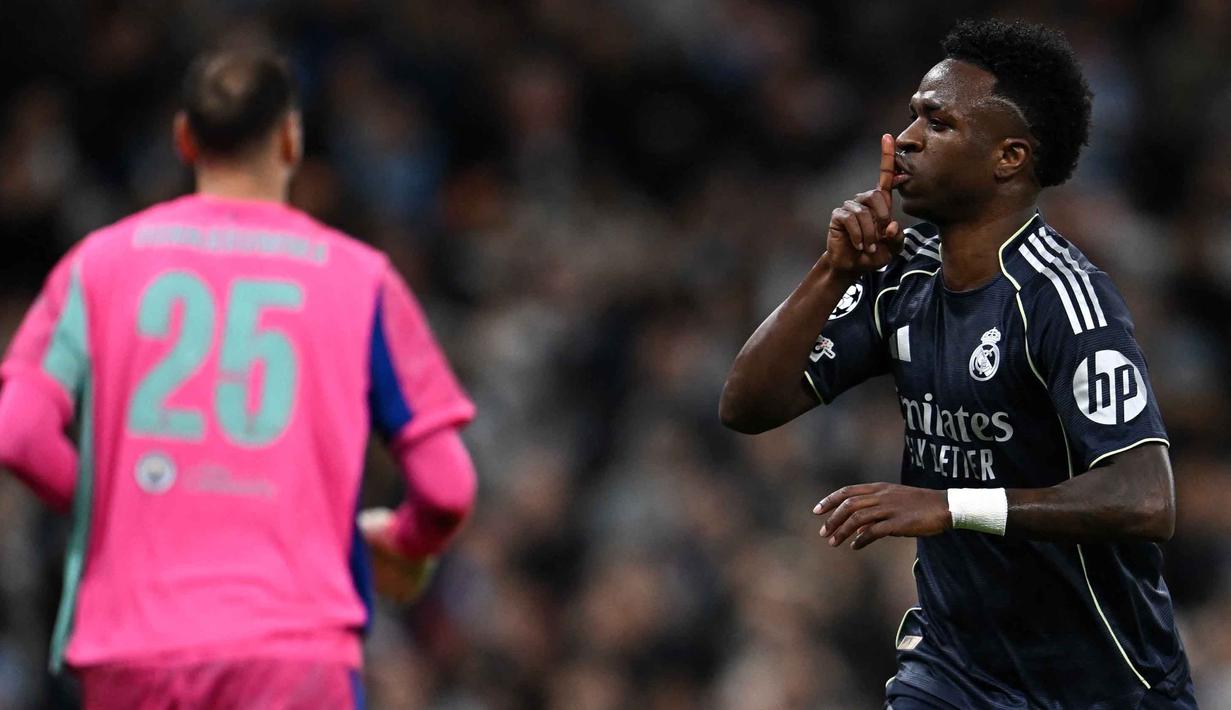 Menit ke-22, melalui eksekusi tendangan penalti, penyerang Real Madrid asal Brasil, Vinicius Junior membawa Los Blancos unggul 1-0. Tampak dalam foto, penyerang Real Madrid asal Brasil, Vinicius Junior, merayakan golnya pada pertandingan leg kedua 16 besar Liga Champions 2025/2026 melawan Manchester City di Etihad Stadium, barat laut Inggris, pada Selasa 17 Maret 2026 waktu setempat atau Rabu (18/3) dini hari WIB. (Paul ELLIS/AFP)