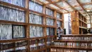 Foto pada 15 September 2018, seorang pria membaca buku di Perpustakaan Liyuan, pinggiran kota Beijing. Di dalam gedung, pengunjung dimanjakan dengan teduhnya sinar matahari yang masuk menembus celah-celah ranting. (FRED DUFOUR/AFP)