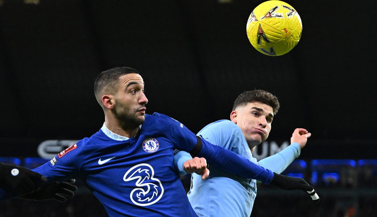 Gelandang Chelsea, Hakim Ziyech berebut bola dengan striker Manchester City, Julian Alvarez dalam laga putaran ketiga Piala FA 2022/2023 di Etihad Stadium, Manchester (8/1/2023). Everton gagal mendapatkan Hakim Ziyech dari Chelsea karena sang pemain lebih memilih bergabung dengan PSG. Namun akibat kesalahan teknis dalam hal surat kontrak, Hakim Ziyech akhirnya gagal menjadi milik PSG dan tetap bertahan bersama Chelsea. (AFP/Oli Scarff)