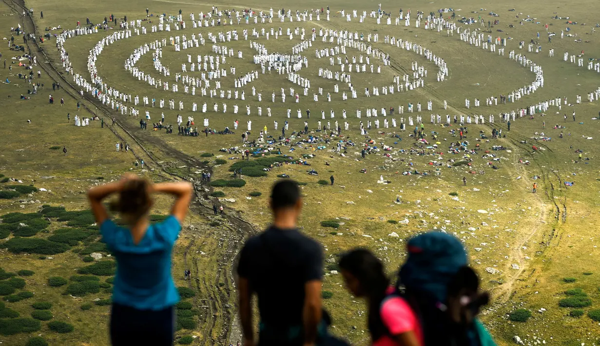 Anggota gerakan keagamaan internasional Persaudaraan Putih melakukan ritual tarian di puncak Gunung Rila, dekat Danau Babreka, Bulgaria, 19 Agustus 2021. Para penari berpakaian serba putih mendaki ke Danau Tujuh Rila pada ketinggian 2.100 meter (6.900 kaki). (NIKOLAY DOYCHINOV/AFP)