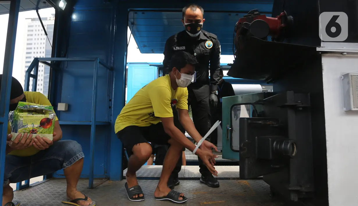 Seorang tersangka memusnahkan narkotika saat rilis hasil Operasi Nila Jaya 2021 di Mapolda Metro Jaya, Jakarta, Kamis (25/11/2021). Polda Metro Jaya melakukan pemusnahan barang bukti narkotika ekstasi, sabu, ganja, happy five dan bubuk sintetis dengan total 1,74 ton. (merdeka.com/Imam Buhori)