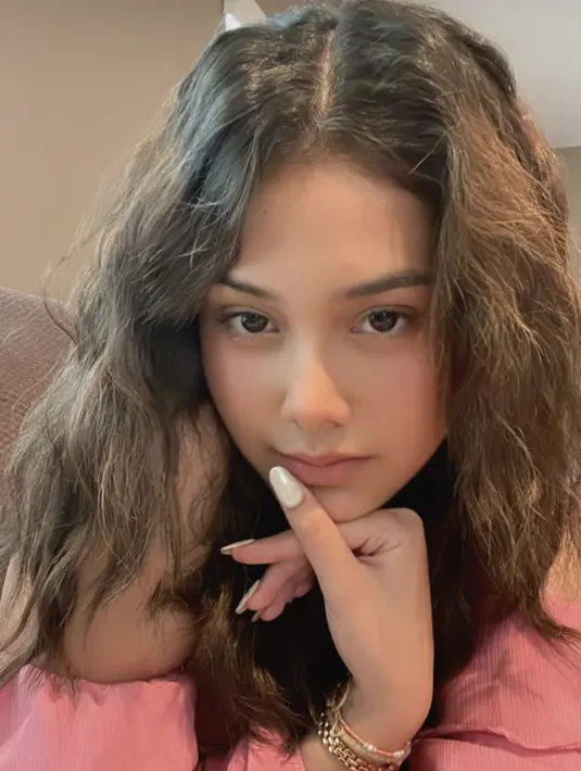 Selain menyiapkan OOTD, ia juga total menata rambutnya. Untuk menambah mood girly, ia mengganti hairstyle rambut ikal natural. [Foto: Instagram @callistaarum]