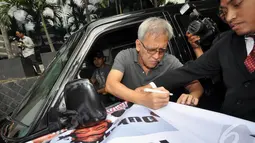 Sebelum meninggalkan Gedung KPK, Iwan Fals sempat menandatangani spanduk yang dibawa aktivis Permindo (Perwakilan Revousi Mental Indonesia), Jakarta, Senin (29/12/2014). (Liputan6.com/Miftahul Hayat)