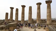 Turis saat mengunjungi Lembah Kuil selama gelombang panas di dekat Agrigento, Sisilia, Italia (11/8/2021). Gelombang panas yang berkelanjutan akan berlangsung hingga akhir pekan dengan suhu diperkirakan mencapai lebih dari 40 derajat Celcius di banyak bagian dari Italia. (AP Photo/Salvatore Cavalli)