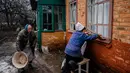 Para wanita lanjut usia bekerja untuk memperbaiki jendela yang pecah setelah penembakan di Chasiv Yar, dekat Bakhmut pada 28 Februari 2023. Presiden Ukraina Volodymyr Zelensky mengatakan situasi di kota Bakhmut, di garis depan timur menjadi semakin sulit setalah pasukan Rusia berusaha merebut kota itu selama lebih dari enam bulan. (Dimitar DILKOFF/AFP)