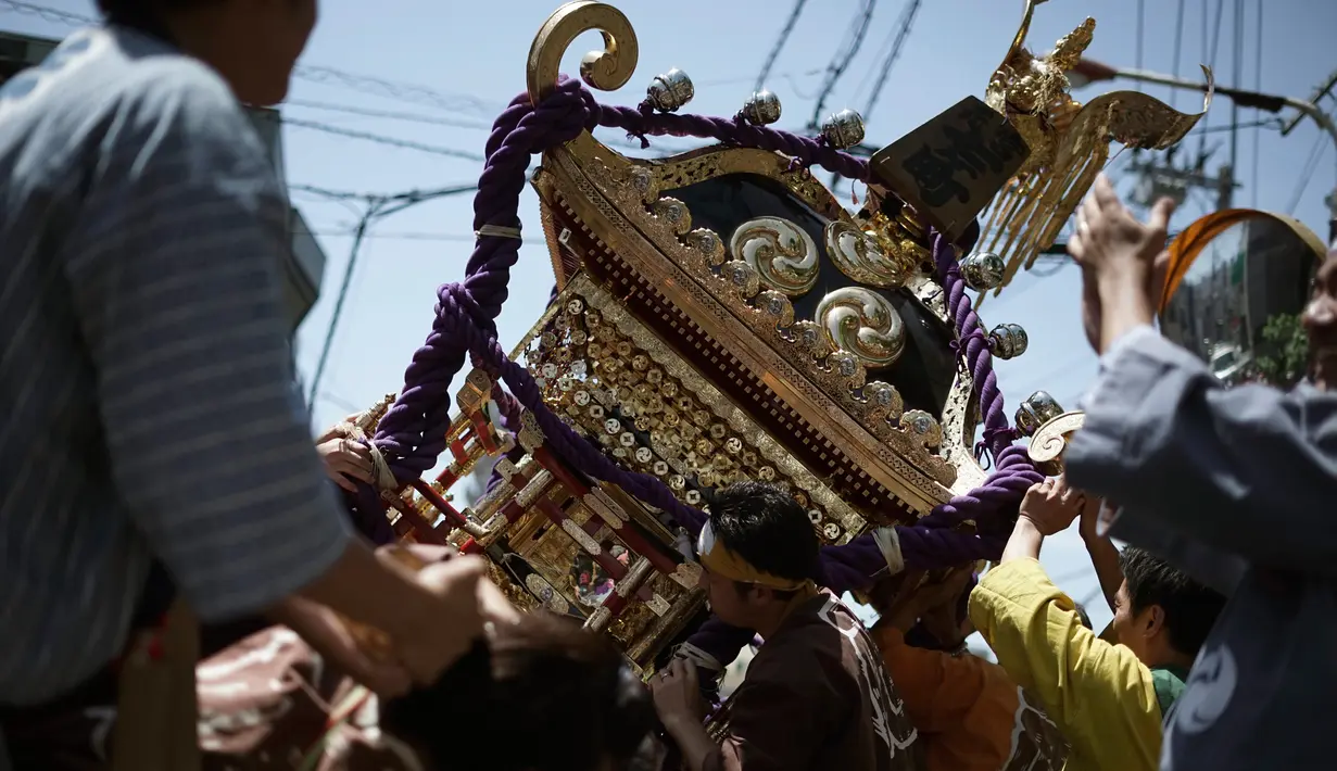 Mikoshi atau tempat suci portabel yang diayunkan para peserta saat festival Tenno-sai di Kuil Susanoo di Tokyo, Jepang (3/6). Festival Tenno-sai ini diyakini dapat mengusir penyakit menular di musim panas. (AP Photo / Eugene Hoshiko)