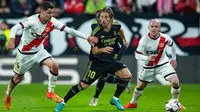 Pemain Real Madrid Luka Modric (tengah) berebut bola dengan pemain Rayo Vallecano Santi Comesana pada pertandingan sepak bola Liga Spanyol di Stadion Vallecas, Madrid, Spanyol, 7 November 2022. Rayo Vallecano mengalahkan Real Madrid dengan skor 3.2. (AP Photo/Manu Fernandez)