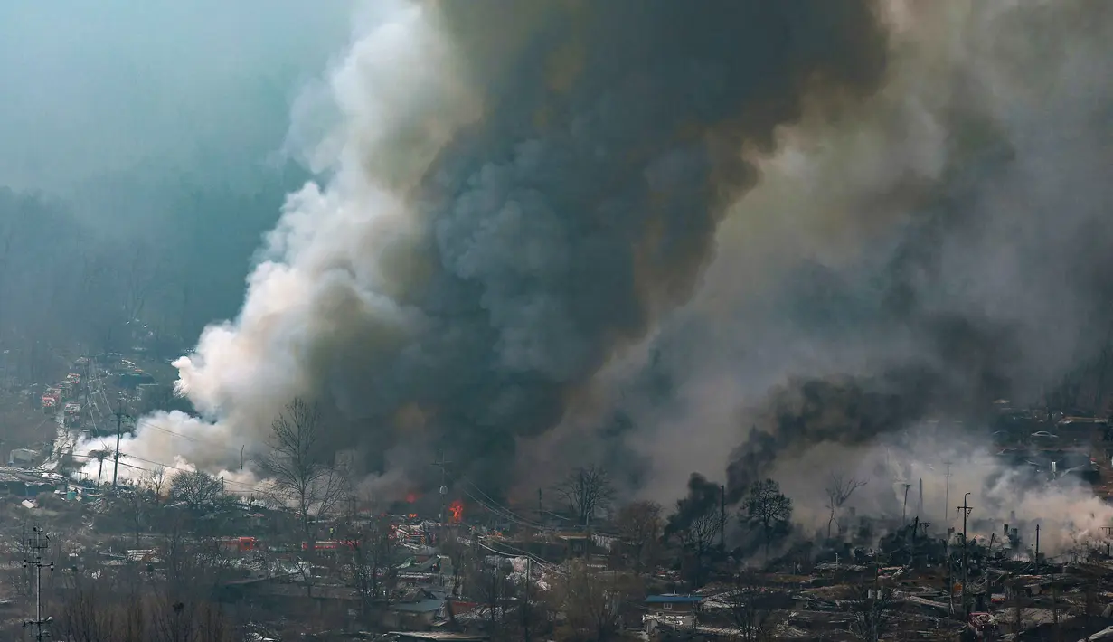 Api dan asap tebal terlihat membumbung tinggi dari permukiman kumuh yang akan direvitalisasi menjadi bangunan hunian bertingkat itu. Tampak dalam foto, asap mengepul dari kebakaran di permukiman kumuh desa Guryong, pemukiman informal terbesar di Seoul, Korea Selatan, pada Jumat 16 Januari 2026. (YONHAP/AFP)