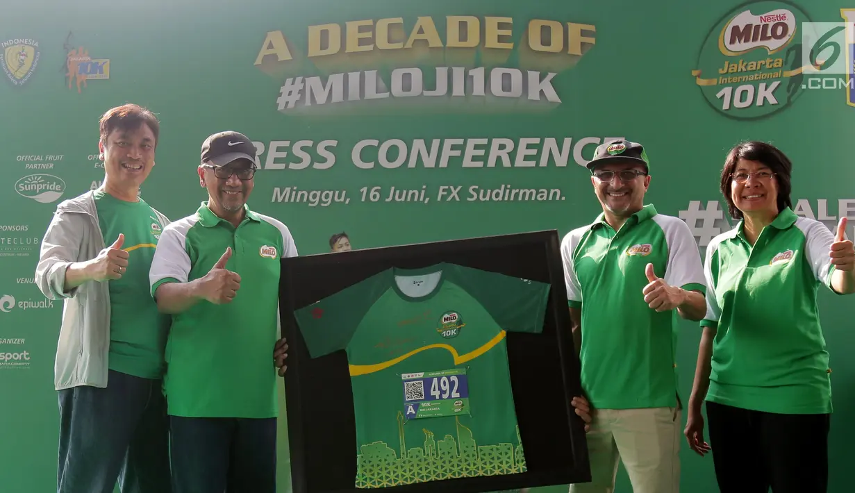 Presdir PT Nestlé Indonesia Dharnesh Gordhon (kedua kanan) secara simbolis menyerahkan kaus dan nomor dada peserta kepada Asisten Kesejahteraan Rakyat Sekda DKI Jakarta, Catur Laswanto (kedua kiri) pada Kick-off MILO Jakarta International 10K di Jakarta, Minggu (16/6/2019). (Liputan6.com/HO/Rizky)