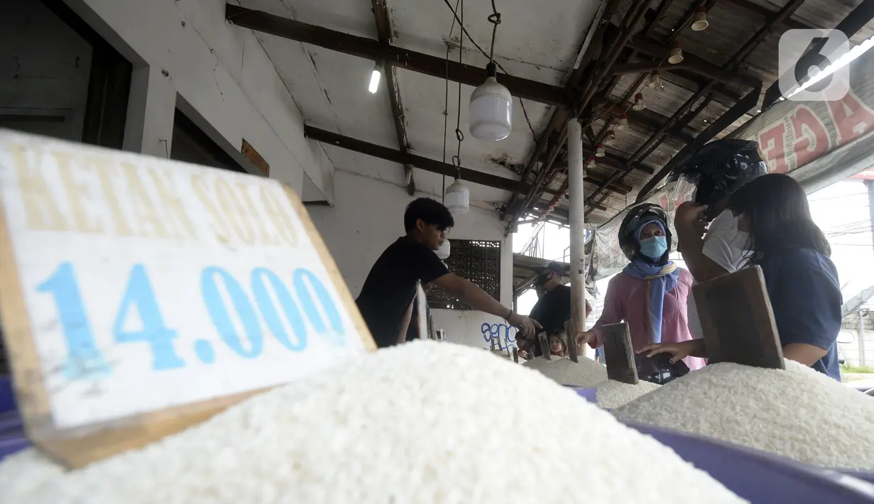 Pedagang beras melayani pembeli di pinggir Jalan Raya Pamulang, Tangerang Selatan, Banten, Jumat (11/12/2020). Jelang Natal dan Tahun Baru 2021, harga beras dipasaran masih normal tidak ada kenaikan. (merdeka.com/Dwi Narwoko)