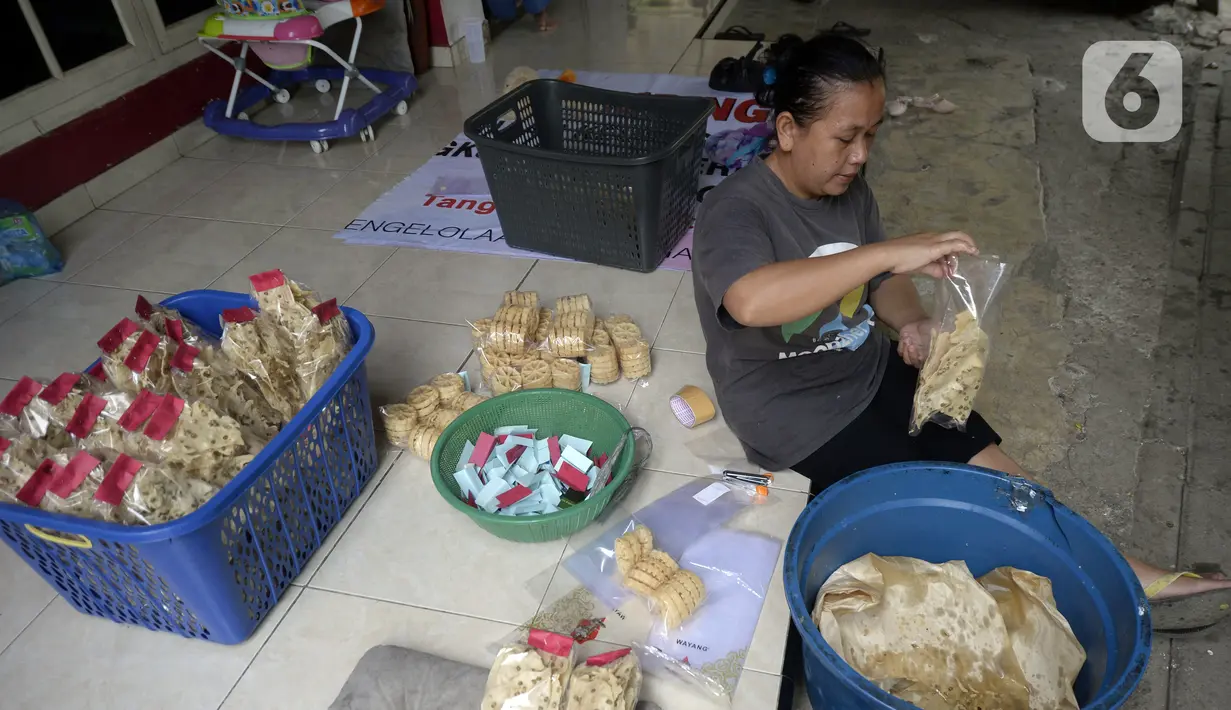 Pekerja mengemas jajanan tradisional kembang goyang di Kelurahan Karangan, Setu, Tangerang Selatan, Banten, Kamis (6/8/2020). Jajanan kue kering berbentuk bunga tersebut dijual dengan harga Rp 5 ribu per bungkus. (merdeka.com/Dwi Narwoko)