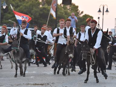 Para peserta berpartisipasi dalam kompetisi balap keledai tradisional ke-53 di Tribunj, Kroasia  (29/8/2020). (Xinhua/Pixsell/Hrvoje Jelavic)