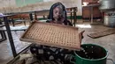 Seorang petugas menghitung kelereng yang akan digunakan untuk pemilihan Presiden Gambia di distrik Tallinding, Serekunda, Gambia (30/11). Kelereng ini digunakan untuk memilih presiden dan sebagai pengganti kertas suara dalam pemilu. (AFP/Marco Longari)