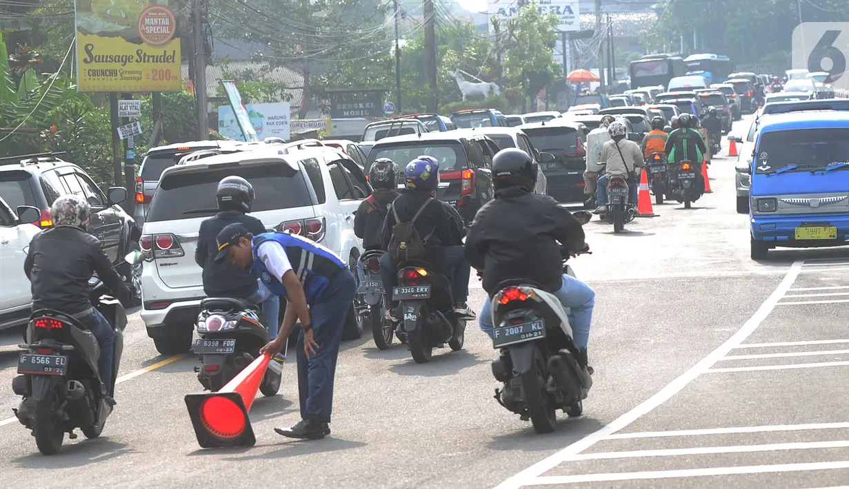 Kondisi lalu lintas saat saat uji coba sistem kanalisasi 2-1 Jalur Puncak di kawasan Gadog, Bogor, Jawa Barat, Minggu (27/10/2019). Pemberlakuan sistem kanalisasi 2-1 Jalur Puncak sebagai alternatif dari sistem buka-tutup yang telah diberlakukan selama ini.(merdeka.com/Arie Basuki)