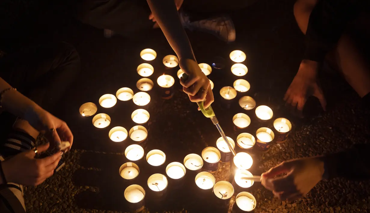 Warga menyalakan lilin pada peringatan 25 tahun pembunuhan Perdana Menteri Israel Yitzhak Rabin, di Rabin Square, Tel Aviv, Kamis (29/10/2020). Sebanyak 25 ribu lilin dinyalakan oleh warga Israel untuk memperingati pembunuhan  Yitzhak Rabin. (AP Photo/Oded Balilty)