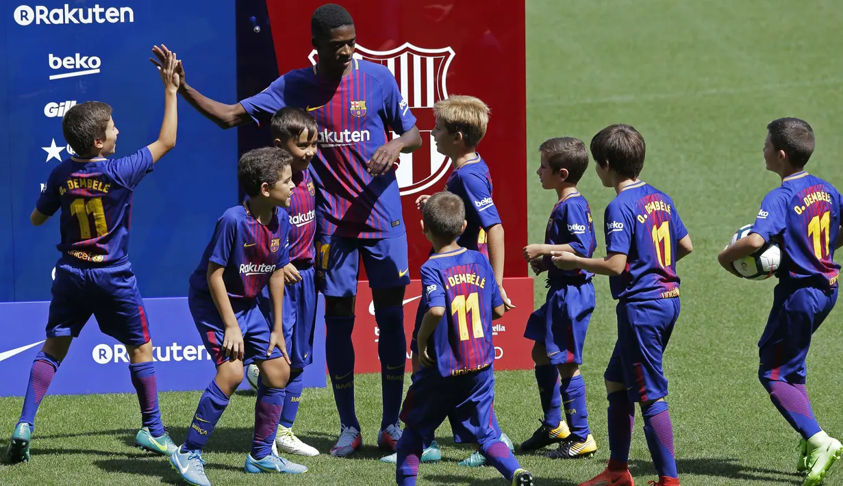 Pemain baru FC Barcelona, Ousmane Dembele memberikan salam kepada anak-anak saat perkenalan di Camp Nou stadium, Barcelona, (27/8/2017). Barcelona menebus Ousmane Dembele sebesar Rp. 2,3 triliun dari Dortmund. (AP/Manu Fernandez)
