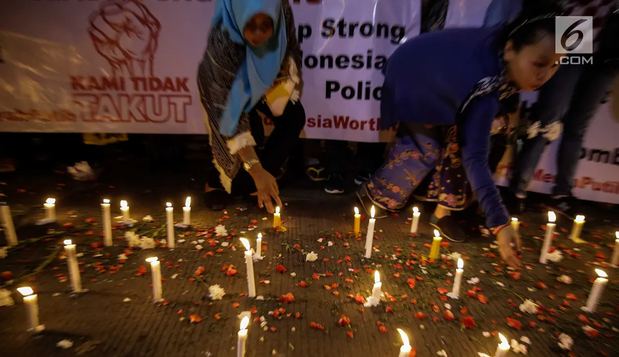 assa dari Solidaritas Merah Putih menggelar aksi lilin dan tabur bunga di lokasi bom Terminal Kampung Melayu, Jakarta, Kamis (25/5). Aksi tersebut sebagai bentuk malam solidaritas duka untuk bom Kampung Melayu.(Liputan6.com/Faizal Fanani)