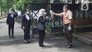 Sejumlah murid dicek suhu sebelum memasuki sekolah di SMKN 51, Jakarta, Rabu (7/4/2021). SMKN 51 melakukan uji coba masuk sekolah dan Uji Sertifikasi Kompetensi (USK) dengan protokol kesehatan yang ketat. (Liputan6.com/Herman Zakharia)
