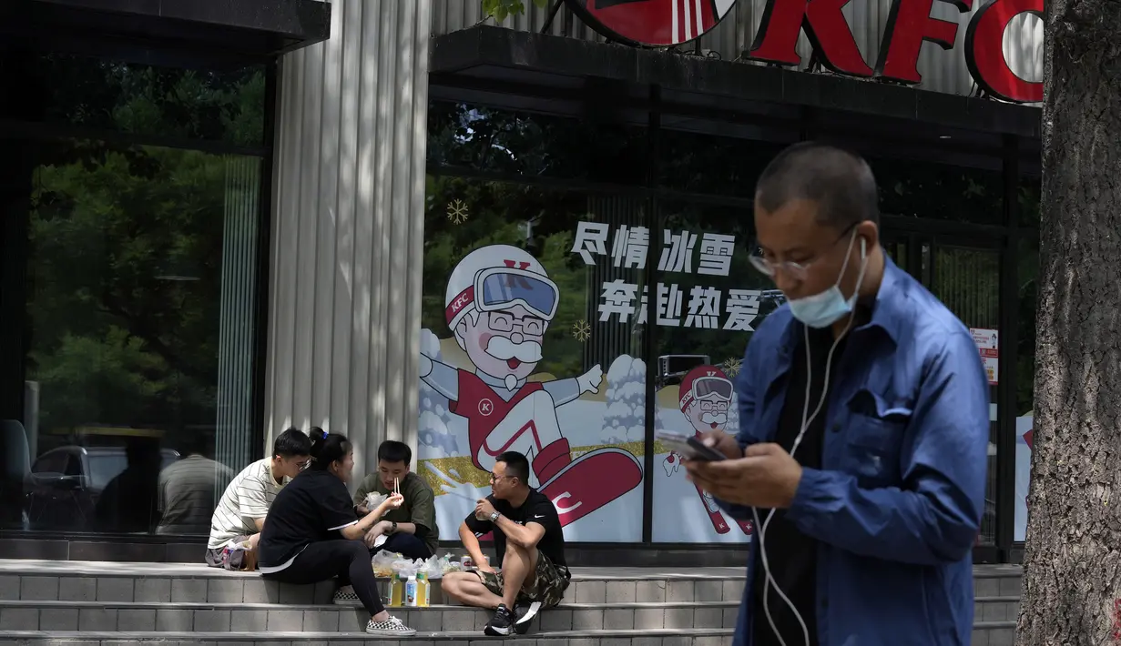 Warga makan di tangga sebuah restoran cepat saji yang tutup di Beijing, China, 15 Juni 2022. Otoritas China di Beijing menutup distrik perbelanjaan dan kehidupan malam utama menyusul lonjakan kasus COVID-19 terkait klub malam. (AP Photo/Ng Han Guan)