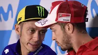 Pebalap Movistar Yamaha, Valentino Rossi, berbincang dengan Andrea Dovizioso saat jumpa pers jelang GP Aragon di Alcaniz, Aragon, Kamis (21/9/2017). Rossi dinyatakan lolos tes medis untuk mengikuti balapan MotoGP Aragon. (AFP/Javier Soriano)