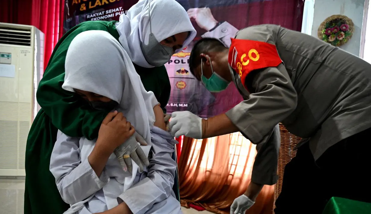 Seorang siswi sekolah menengah pertama menerima dosis vaksin Sinovac pada acara vaksinasi virus corona COVID-19 di Blang Bintang, Provinsi Aceh, 21 September 2021. (CHAIDEER MAHYUDDIN/AFP)