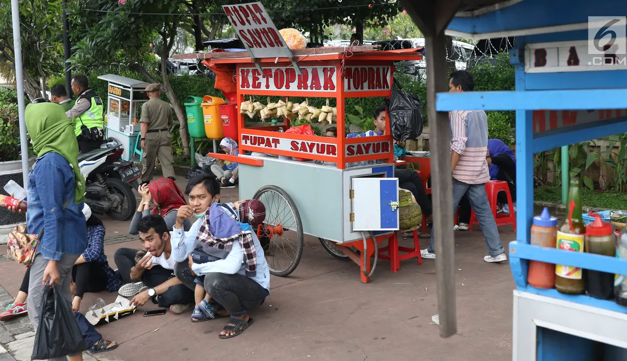 Pedagang kaki lima menjajakan makanan dan minuman di sisi jalan sekitar kawasan Patung Kuda Jakarta, Rabu (5/1/2019). Mereka mencoba peruntungan saat para buruh melakukan aksi perayaan Hari Buruh International atau May Day. (Liputan6.com/Helmi Fithriansyah)