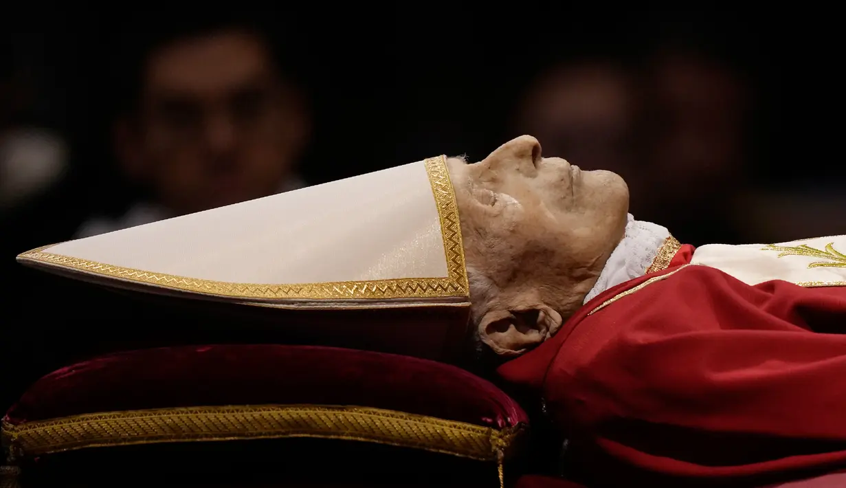 Jenazah mendiang Paus Emeritus Benediktus XVI disemayamkan di dalam Basilika Santo Petrus, Vatikan, Senin (2/1/2023). Benediktus XVI, teolog Jerman yang akan dikenang sebagai paus pertama dalam 600 tahun yang mengundurkan diri, telah meninggal pada 31 Desember 2022 di usia 95 tahun. (AP Photo/Andrew Medichini)