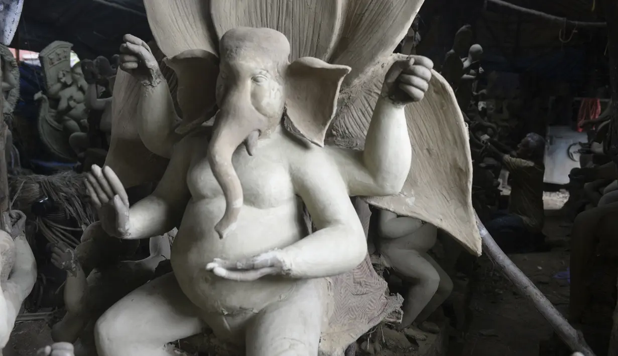 Patung Dewa Ganesha terlihat di sebuah bengkel di pinggiran Hyderabad, India, Rabu (18/8/2021). ​Patung ramah lingkungan yang dibuat jelang perayaan Ganesh Chaturthi tersebut dibuat dari lumpur, serat rami, dan bambu untuk mengurangi polusi air. (NOAH SEELAM/AFP)
