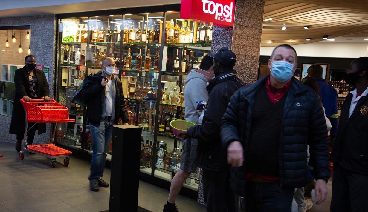 Pelanggan menunggu pembukaan kembali toko minuman keras ketika Afrika Selatan mencabut larangan penjualan alkohol dan rokok di Johannesburg, Selasa (18/8/2020). Pembelian alkohol dan rokok dilarang ketika Afrika Selatan memberlakukan lockdown ketat pada 27 Maret 2020. (AP Photo/Denis Farrell)