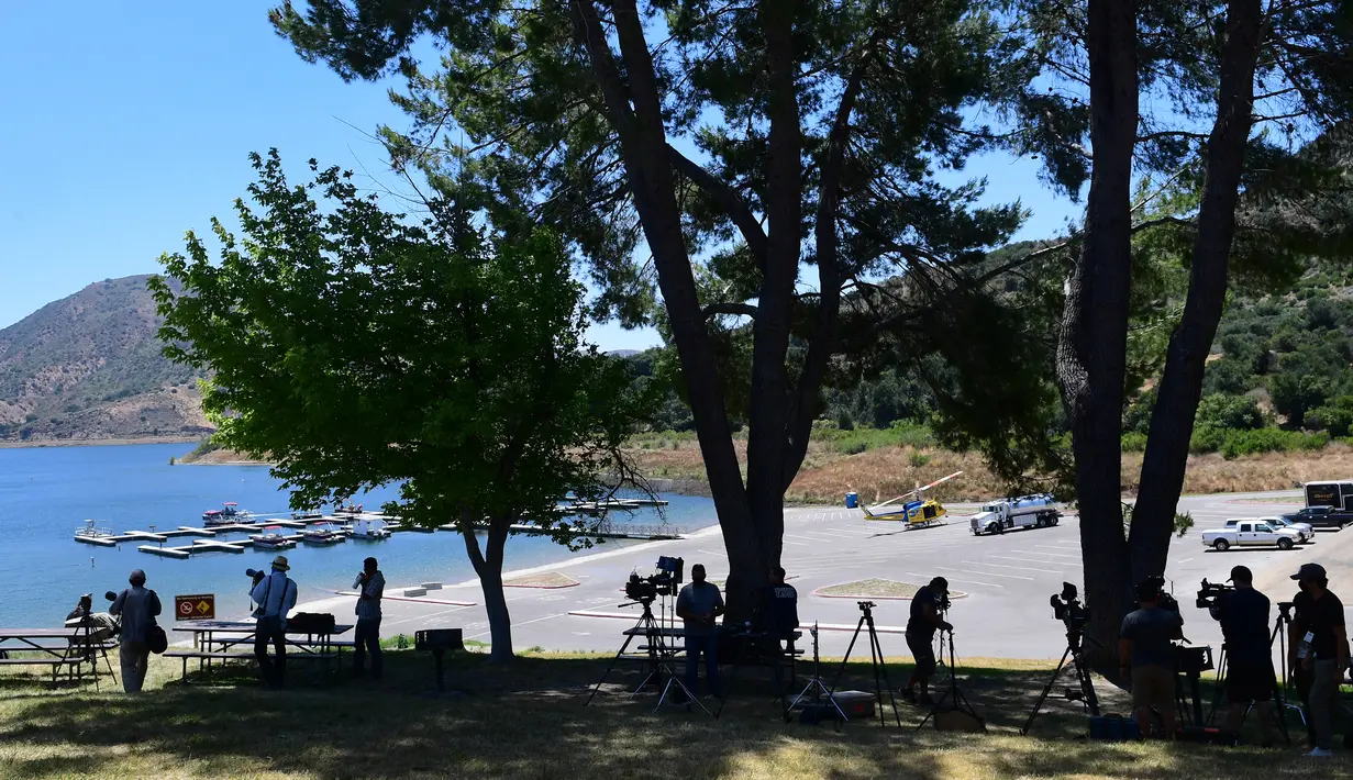 Awak media berkumpul di Danau Piru, di mana jasad aktris Glee Naya Rivera ditemukan di California, Senin (13/7/2020). Kepolisian wilayah Ventura pada Senin (13/7) pagi mengumumkan telah mengangkat jasad  Naya Rivera dari Danau Piru. (Frederic J. BROWN / AFP)