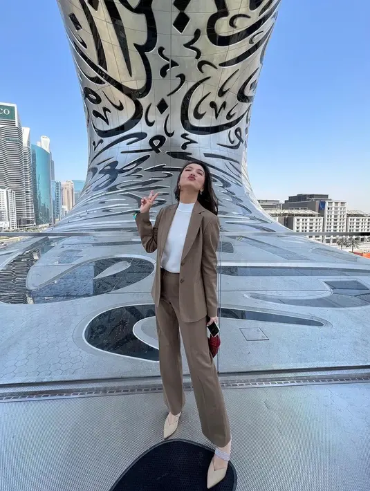 Memadukan turtle neck putih dengan setelan jas ini juga bisa dijadikan sebagai inspirasi. Raline juga memilih untuk menggunakan mini bag sederhana serta heels berwarna krem. (Liputan6.com/IG/@ralineshah)