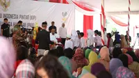 Presiden Jokowi menyerahkan secara simbolis buku rekening PKH dan KIP (Liputan6.com / Nefri Inge)