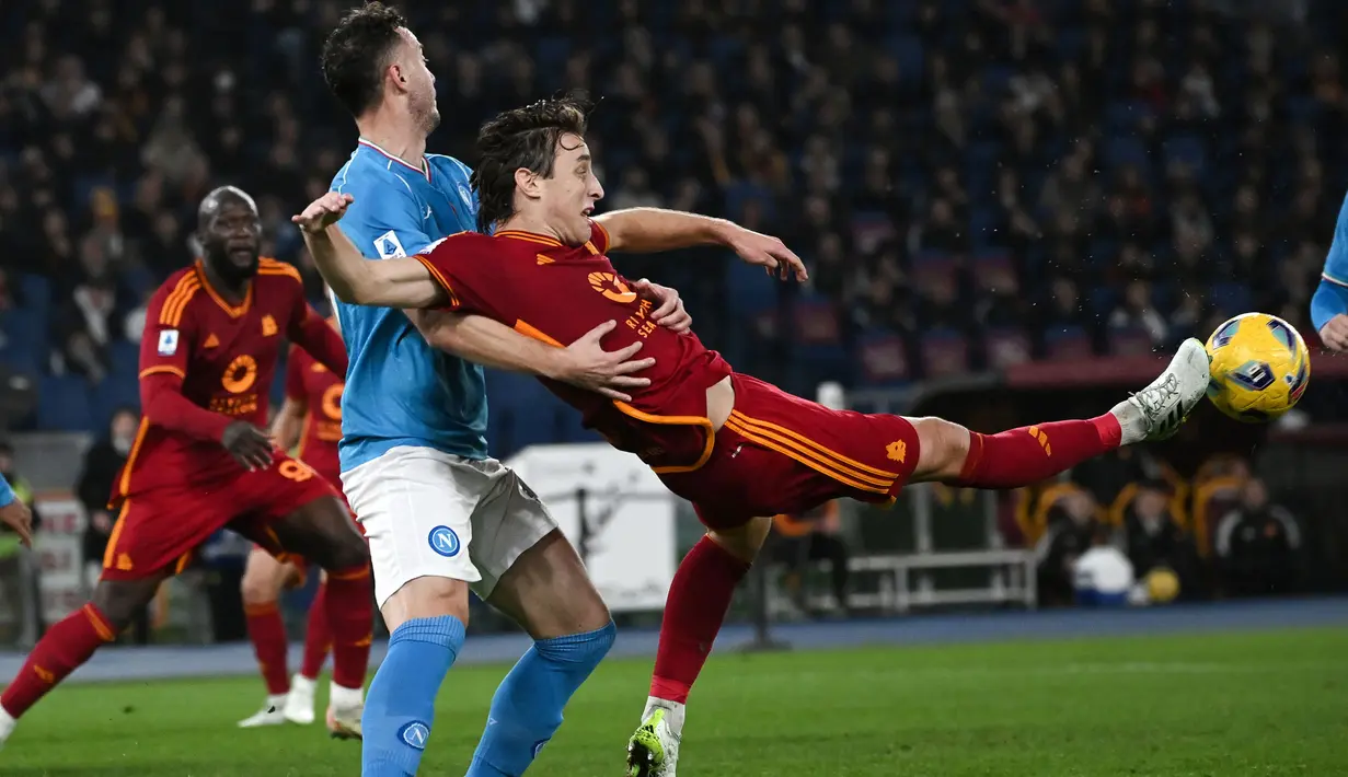 Gelandang AS Roma, Edoardo Bove (kanan) berusaha mengontrol bola di depan bek Napoli, Amir Rrahmani pada laga pekan ke-17 Liga Italia 2023/2024 di Olympic Stadium, Roma, Minggu (24/12/2023) dini hari WIB. (AFP/Tiziana Fabi)