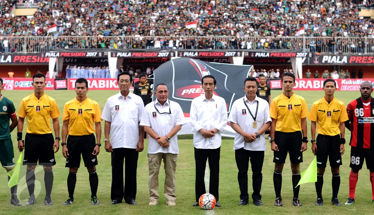 Presiden Joko Widodo (tengah) berfoto bersama pemain PSS dan Persipura usai membuka turnamen Piala Presiden 2017 di Stadion Maguwoharjo, Sleman, Sabtu (4/2). 31.000 penonton menyaksikan laga pembuka Piala Presiden 2017. (Liputan6.com/Helmi Fithriansyah)