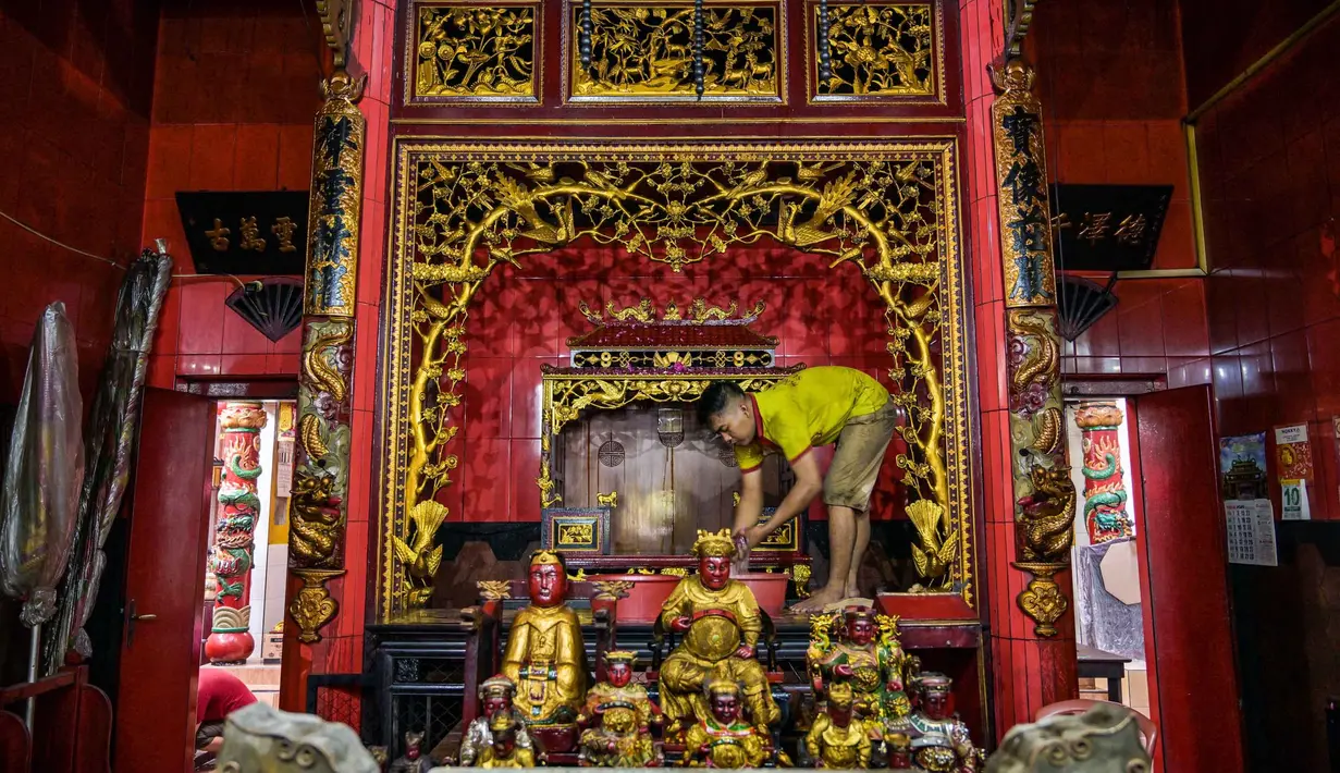 Selain cuci Rupang, persiapan Imlek juga meliputi pergantian lampion, lilin, serta sembahyang kepada leluhur. Tampak dalam foto, para sukarelawan membersihkan patung-patung dewa di Kuil Hong San Ko Tee, Surabaya, Jawa Timur, pada Rabu 11 Februari 2026. (JUNI KRISWANTO/AFP)