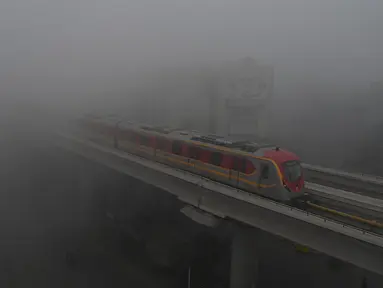 Kereta Metro Jalur Oranye (OLMT) melaju di tengah cuaca berkabut di Lahore (21/12/2022). Kabut tebal kembali menyelimuti berbagai kota di Punjab, termasuk Lahore pada malam hari antara Selasa dan Rabu, melumpuhkan kehidupan sehari-hari dan mengganggu lalu lintas jalan raya dan udara.(AFP/Arif Ali)