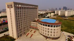 Sebuah gedung universitas yang menyerupai kloset duduk di Zhengzhou, Provinsi Henan, China, (21/9). Gedung universitas ini menjadi bahan candaan dan olok-olokan oleh warganet. (AFP Photo/Str/China Out)