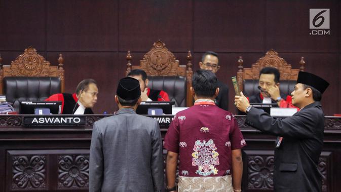 Saksi Tim Hukum Jokowi, Candra Irawan (baju batik) saat disumpah sebelum memberikan kesaksian di hadapan hakim konstitusi dalam sidang lanjutan sengketa Pilpres 2019 di Gedung MK, Jakarta, Jumat (21/6/2019). Candra merupakan tenaga ahli di Fraksi PDI Perjuangan. (Liputan6.com/Johan Tallo)