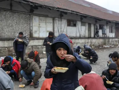 Sejumlah imigran makan makanan gratis di Belgrade, Serbia, Kamis (22/12). (REUTERS / Marko Djurica)
