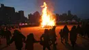 Warga Korea Selatan berkumpul di dekat api unggun besar dalam sebuah acara perayaan "Jeongwol Daeboreum" (Bulan Purnama) di sebuah taman di Seoul, Korea Selatan (1/3). (AFP Photo/Jung Yeon-je)