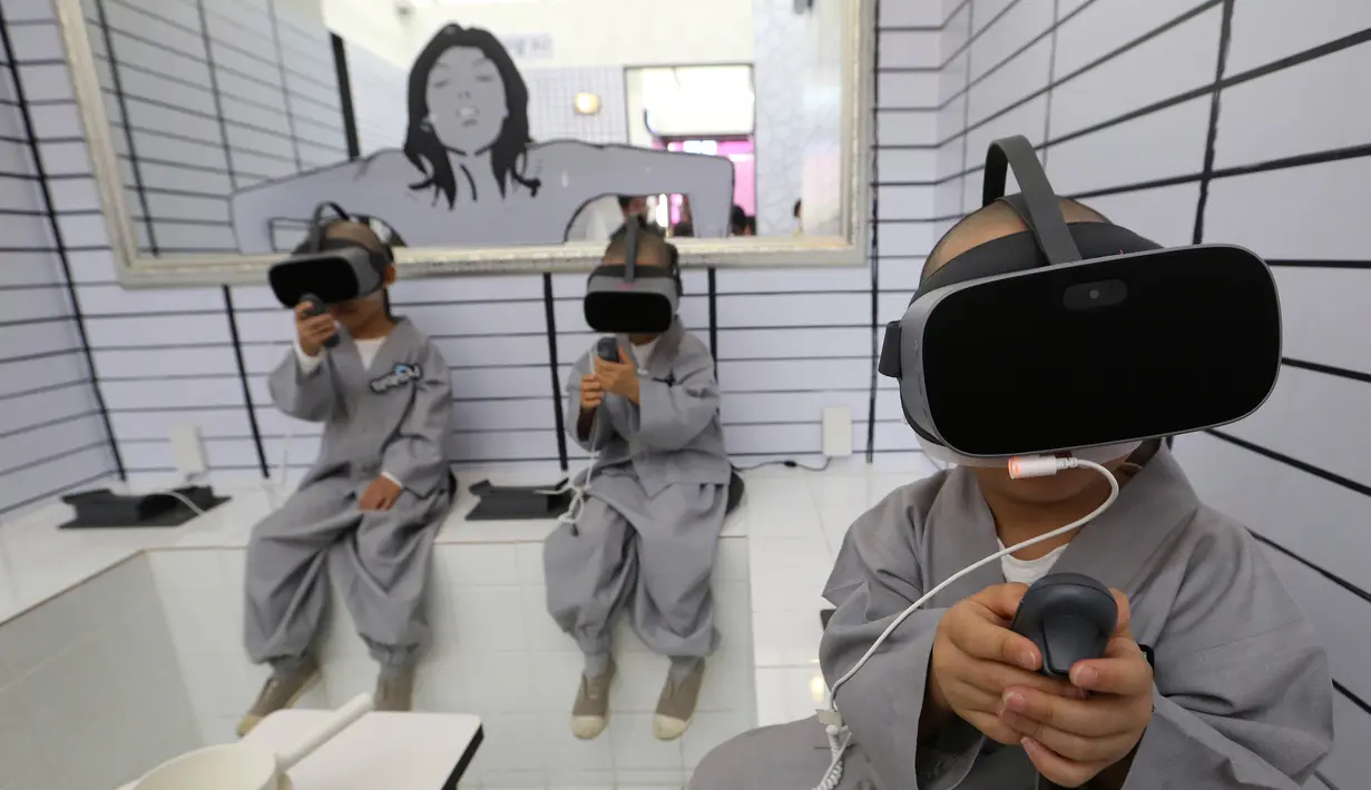 Tiga anak lelaki berkepala botak bermain Virtual Reality (VR) menggunakan layanan 5G di tempat pengalaman LG UPlus 5G di Seoul, Korea Selatan (7/5/ 2019). Sepuluh anak terpilih mendapatkan pengalaman menjadi biksu dalam rangkaian acara peringatan hari lahir Buddha. (AP Photo/Ahn Young-joon)