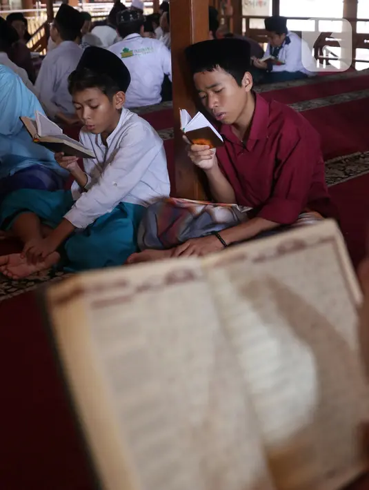 Santri saat mengaji menggunakan Alquran di pondok pesantren kawasan Tangerang, Senin, (26/4/2021). Bulan Ramdhan banyak dimanfaatkan para santri tersebut untuk mematangkan hafalan Alquran hingga khatam. (Liputan6.com/Angga Yuniar)