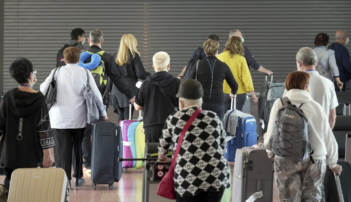 Wisatawan asing berjalan setibanya di Bandara Internasional Haneda, Tokyo, Selasa (11/10/2022). Kebijakan pelonggaran persyaratan kontrol perbatasan Covid-19 merupakan langkah akan menghidupkan kembali industri pariwisata Jepang yang sempat "mati suri" akibat pandemi Covid-19. (AP Photo/Eugene Hoshiko)