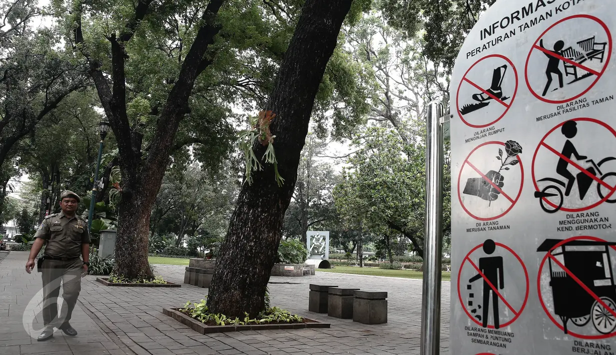 Seorang petugas Satpol PP ketika berpatroli di sekitar Taman Suropati, Jakarta, Selasa (14/6). Kini, Taman Suropati disterilkan dari PKL dan bersih dari parkir liar yang biasa terlihat di bahu jalan tepian taman. (Liputan6.com/Faizal Fanani)