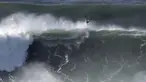 Seorang peselancar keluar dari ombak selama sesi selancar derek di Praia do Norte di Nazare, Portugal (29/10/2020). Gelombang besar, yang ditimbulkan oleh Badai Epsilon di Atlantik Utara, mencapai Portugis pantai barat menarik peselancar ombak besar ke Nazare. (AP Photo/Pedro Rocha)