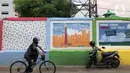 Pesepeda melintas di depan mural bertema Kota Jakarta di sekitar Rusunawa KS Tubun, Jakarta, Senin (23/11/2020). Mural tersebut dibuat guna memercantik lingkungan di sekitar rusun agar lebih berwarna dan tidak tampak kumuh. (Liputan6.com/Immanuel Antonius)
