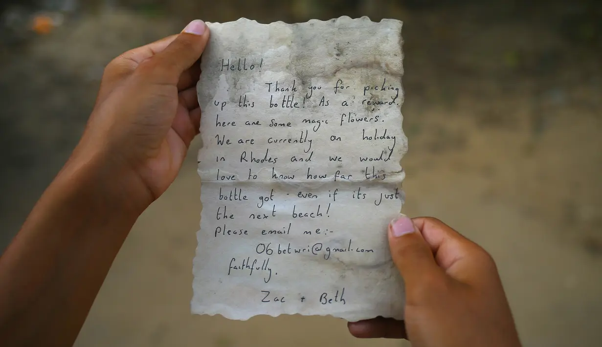 Sebuah kertas berisi pesan yang ditemukan dalam botol oleh nelayan Palestina, Jihad al-Soltan di lepas pantai Jalur Gaza, Selasa (22/8). Diketahui, bahwa botol surat itu telah terombang-ambing dan mengarungi perairan sejauh 800 km. (MOHAMMED ABED/AFP)