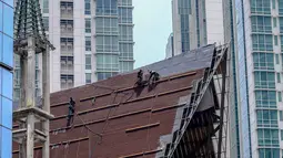 Aktivitas pekerja di atas atap gereja tanpa alat pengaman lengkap, Jakarta, Rabu (12/2/2020). Kemnaker mengatakan tingginya angka kecelakaan kerja di Indonesia disebabkan tidak maksimalnya penerapan K3 yang diatur dalam UU No1 Tahun 1970 tentang Keselamatan Kerja. (Liputan6.com/Faizal Fanani)